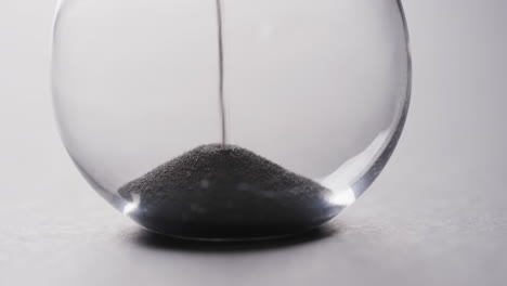 video of hourglass with sand pouring, copy space on white background