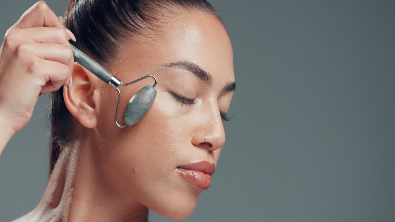 Woman using facial roller for skincare