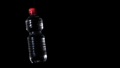 plastic bottle spinning on black surface