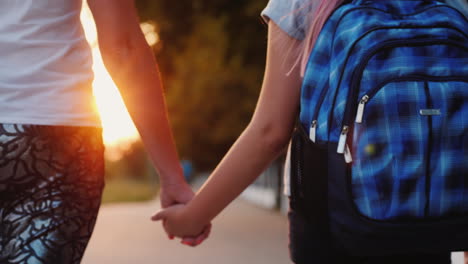 mamá lleva al niño de la mano a la escuela
