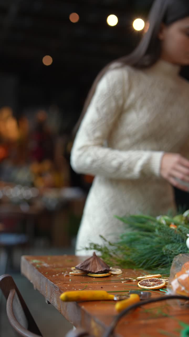 una mujer haciendo una corona de navidad.