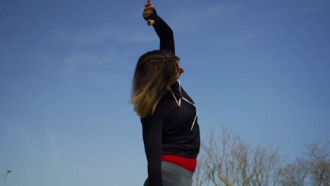 athletic young woman in sportswear exercising in park