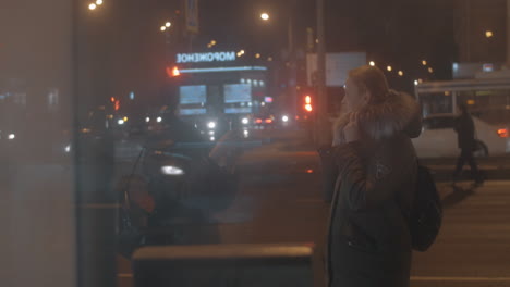 Amigos-Haciendo-Fotos-Con-El-Celular-Mientras-Esperan-El-Autobús-En-La-Ciudad-De-Noche.