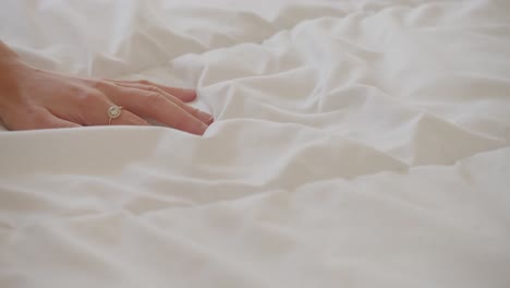 hand of woman touching soft white cover duvet