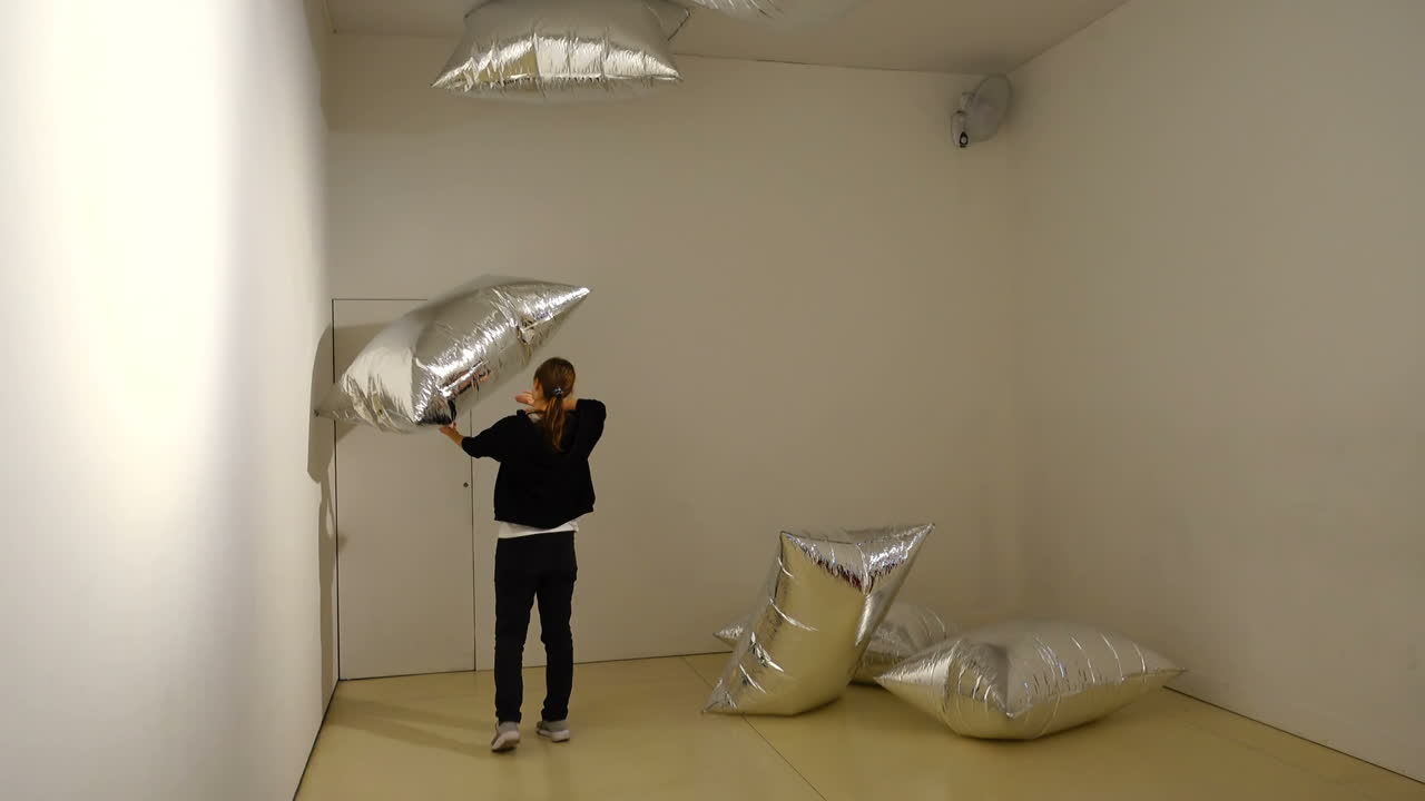 Exibition Andy Warhol "Warhol. Mechanical Art." A girl playing with "silver clouds" in the CaixaForum Madrid