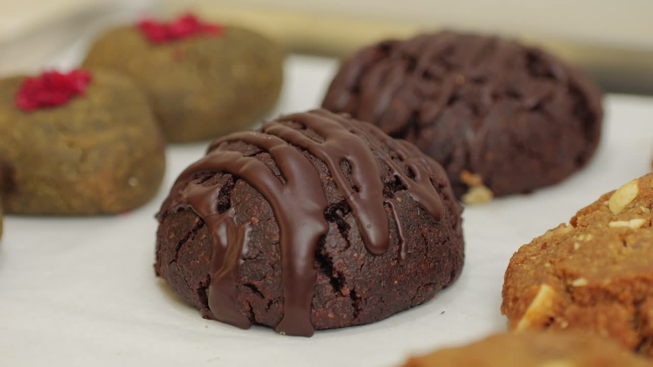 Fresh brownie chocolate cookies in bakery shop close-up. Artisan sweets and bread is making by skill bakers using natural and high-quality ingredients. Food with health and flavour benefits. Sweet breads for dessert and breakfast. Bakery shop and market