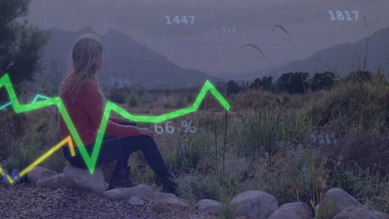 Woman sitting on rocks facing valley, data starting analytics graphs floating over her and moving