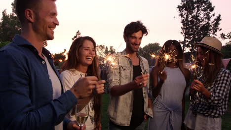 group of friends with sparklers enjoying outdoor party