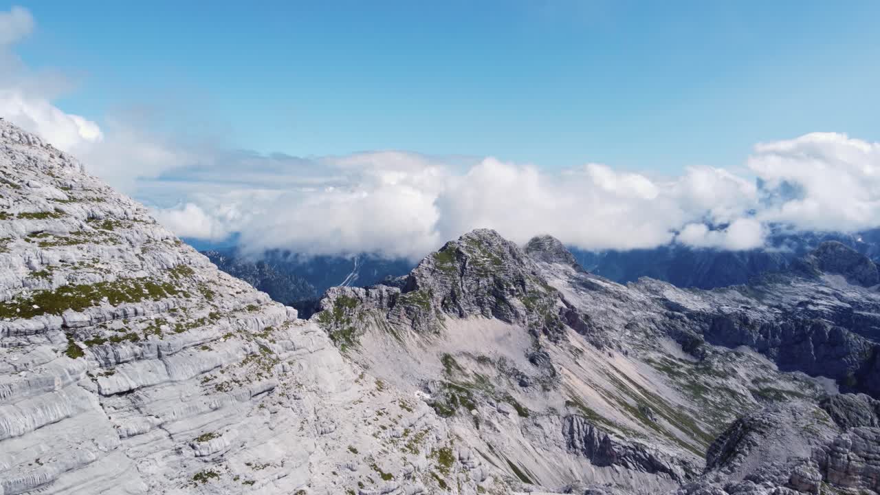 el espectacular paisaje montañoso aéreo se revela en lo alto de los alpes mientras vuela cerca de un pico de piedra caliza