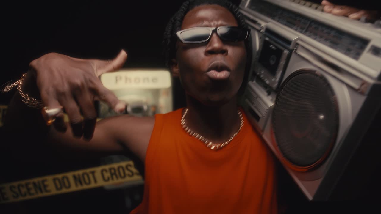 Black Hip-Hop Artist with Boombox on Shoulder Rapping to Camera at Crime Scene