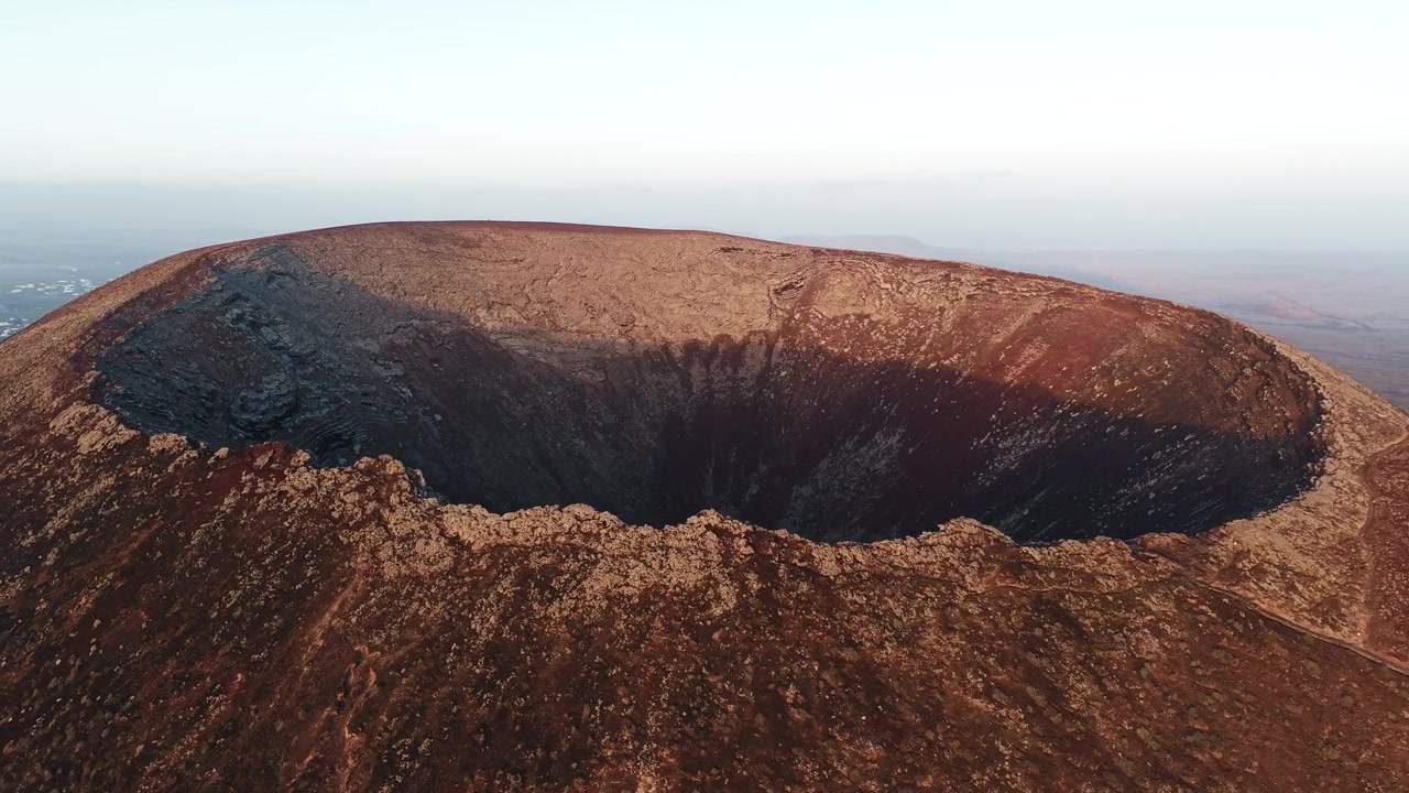 Veduta aerea di un cratere vulcanico al tramonto.