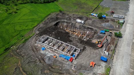 cement mixer truck, excavator, and loader at the construction site of building. - aerial shot