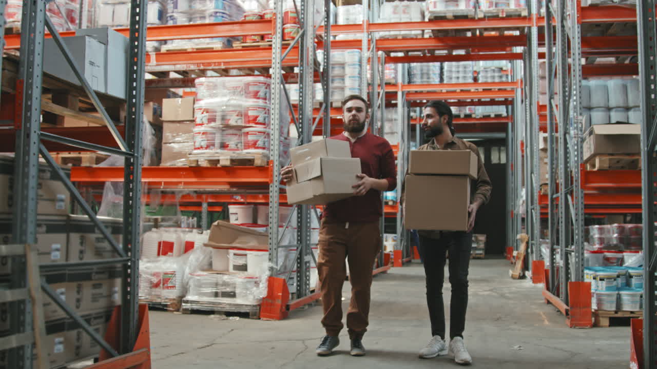 Slowmo of Workers Carrying Boxes in Warehouse