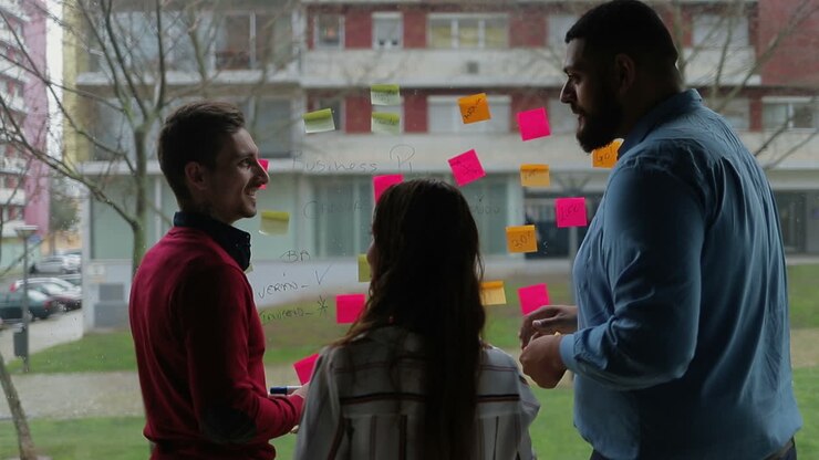 Smiling managers working over new business plan near window.