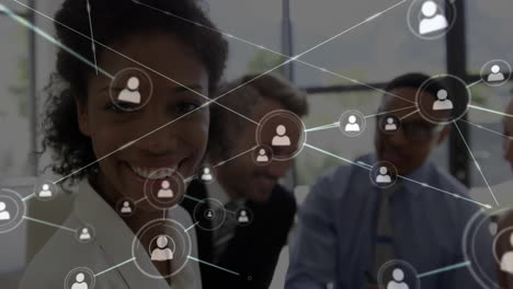 animation of network of people icons over happy diverse colleagues at office