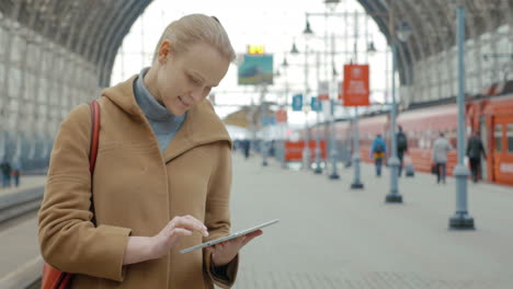 Frau-Mit-Tablet-Auf-Dem-Bahnhof