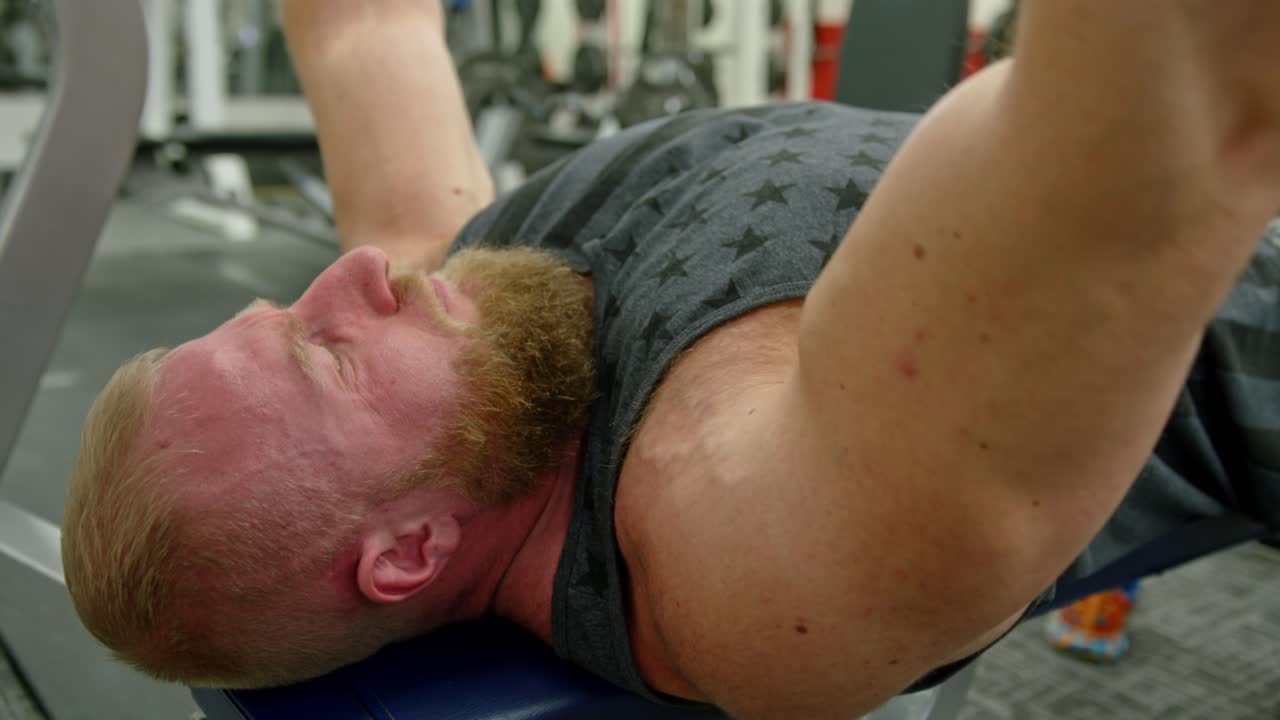 Active bodybuilder young man lifting heavy weights