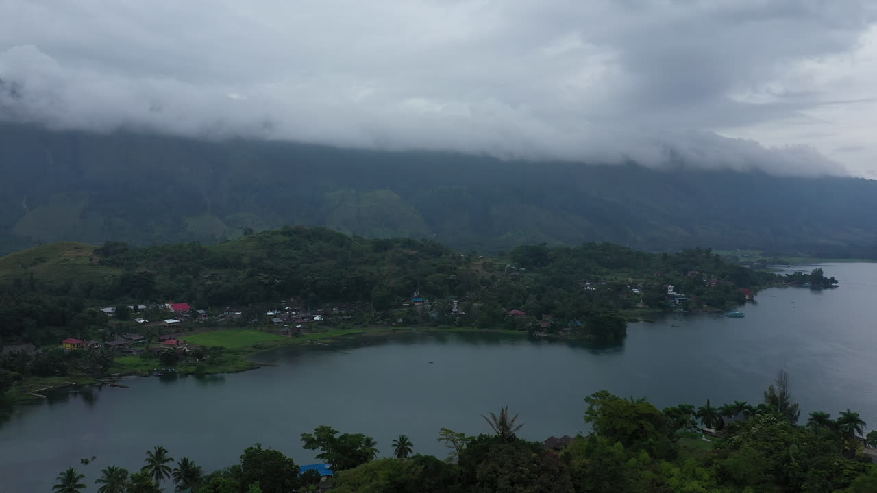 sobrevuelo de drones aéreos en un día lluvioso de un pueblo junto al lago en la isla de samosir en el lago toba en el norte de sumatra, indonesia