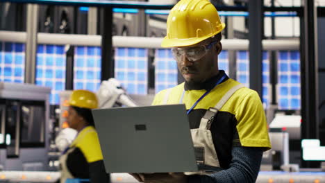 vertical video portrait of smiling technician in solar panels factory oversees assembly lines