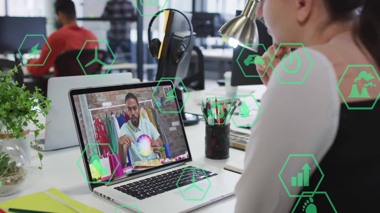 Watching animation, person using laptop with digital icons overlaying screen