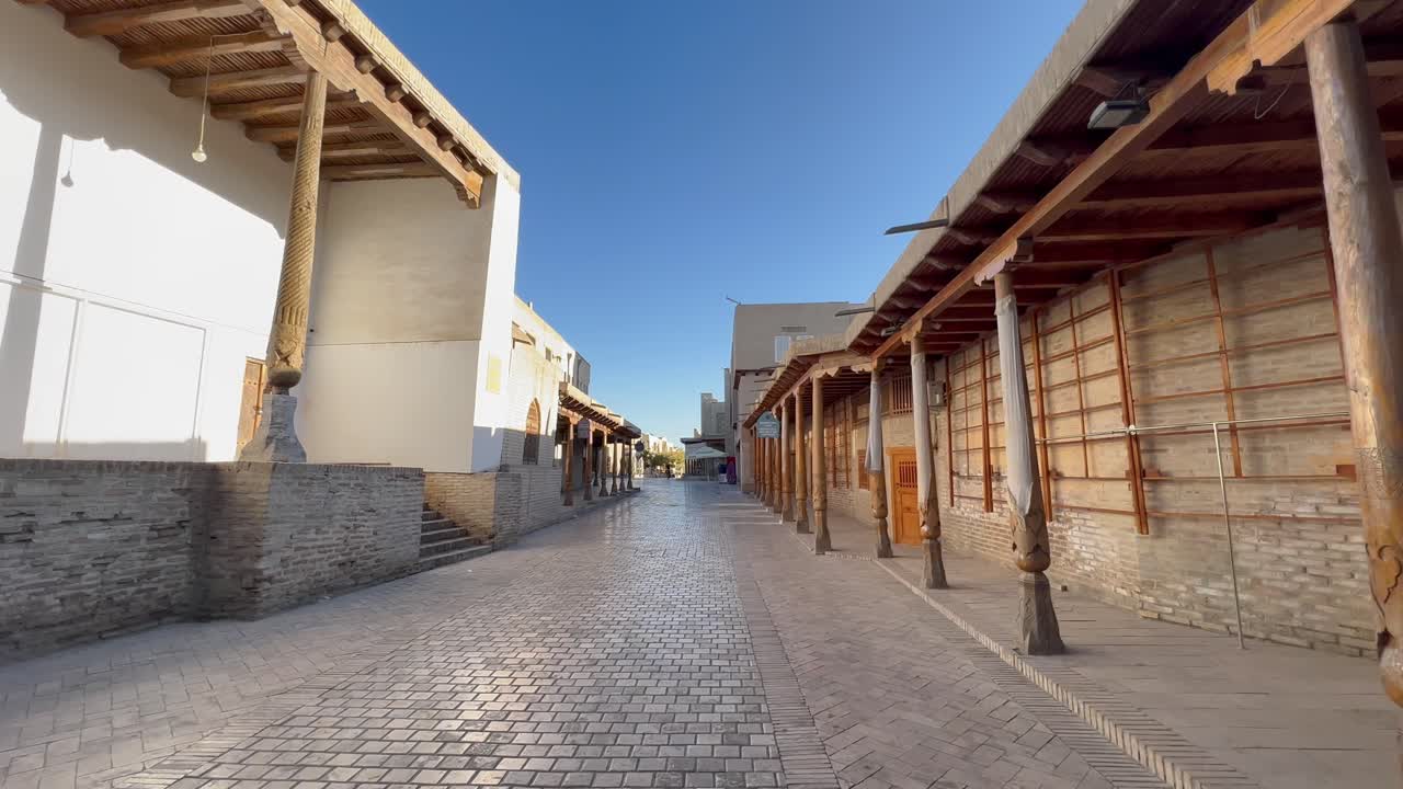 Ripresa 4K con gimbal: camminando per le antiche strade del Sito Patrimonio dell'UNESCO nella Città Vecchia di Bukhara, Uzbekistan