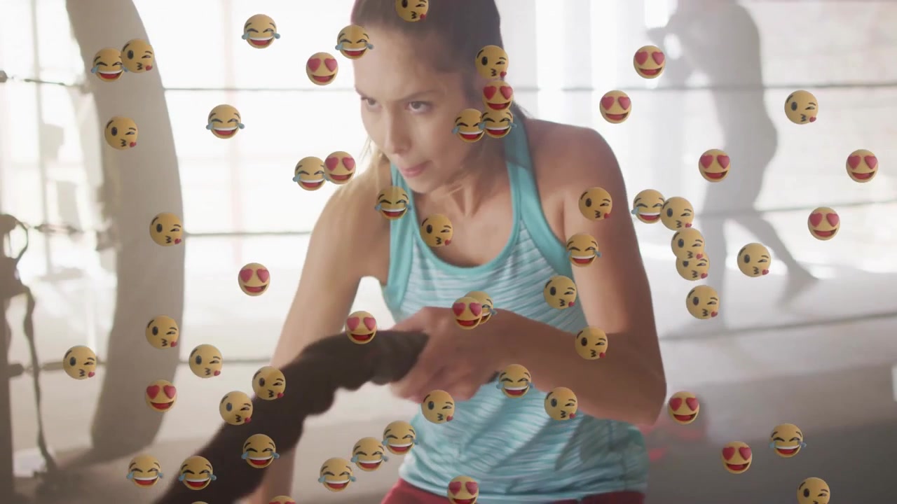 Kvinnelig idrettsutøver løfter battle ropes, genererer emoji-reaksjoner og øker energien i boksetreningen.