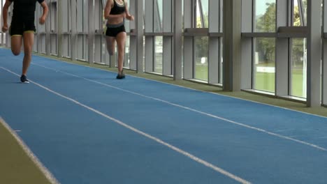 couple racing on indoor track