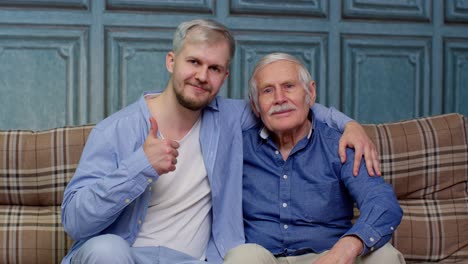 happy different male generations family of senior father and adult son or grandson showing thumbs up