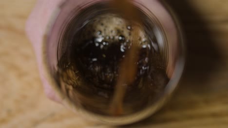 pint of irish stout being poured into glass being held to celebrate st patricks day