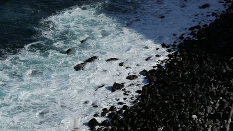 waves crashing on small rocks on the coast