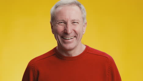 smiling older man in red sweater
