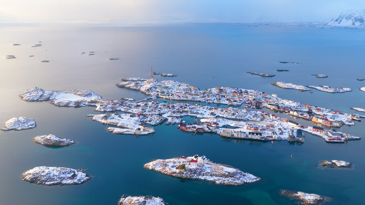 Filmatisk luftfoto av de ikoniske snødekte øyene og fargerike husene i Henningsvær, Lofoten, fanget en lys vintermorgen