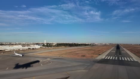 Silhouette-of-a-jet-airplane-over-the-ground-during-a-real-time-landing-at-the-golden-hour