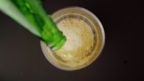 vertiendo cerveza espumosa en un vaso desde arriba