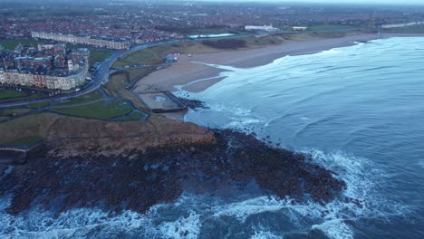 tynemouth longsands: gentle waves washing onto quiet beach as the sun rises