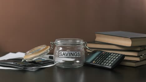 businessman taking money from glass with savings