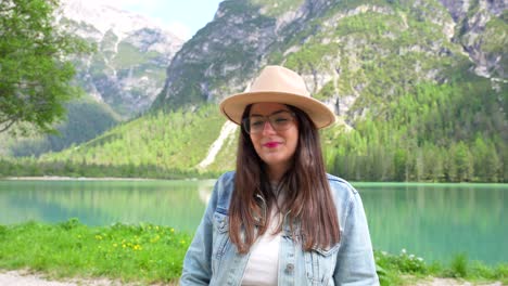 portrait of young woman smiling at camera with lago di landro in background