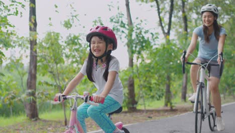 mother and daughter enjoying a bike ride in the park