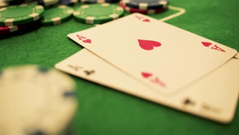 two aces thrown on green casino table - chips-checks-casino token- poker - extreme close up - slow motion