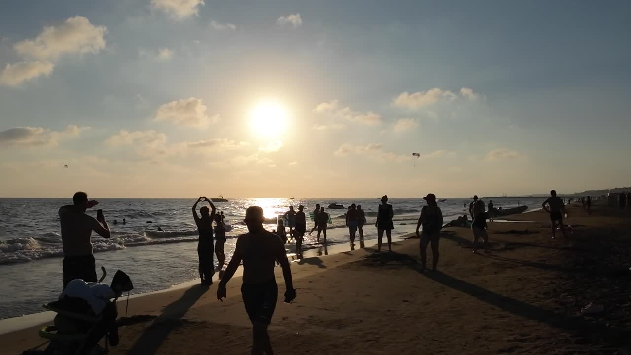 Sunset at the Beach: People Enjoying Summer Vacation