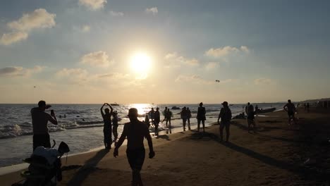 sunset at the beach: people enjoying summer vacation