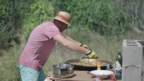 man cooking traditional spanish paella outdoors