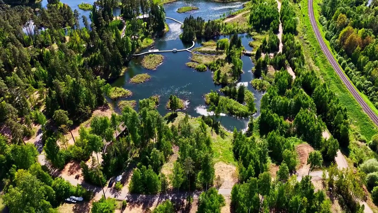 Zelené lotyšské jezero s ostrovy, stromy a budovami luxusního resortu