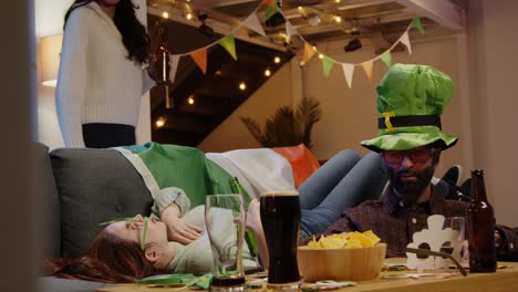 groep vrienden die zich verkleeden met ierse nieuwigheden en rekwisieten thuis of in een bar vieren op st. patrick's day party 1