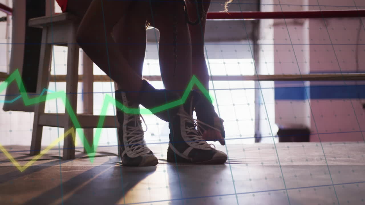 Boxer tying shoes in gym with financial graph animation overlay