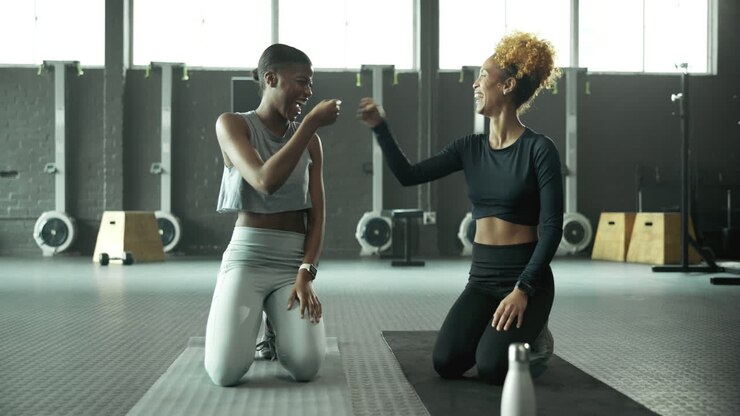 Zwei Frauen in Sportkleidung im Fitnessstudio.