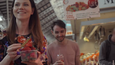 Una-Pareja-Comprando-Una-Caja-De-Fresas-En-Un-Mercado.