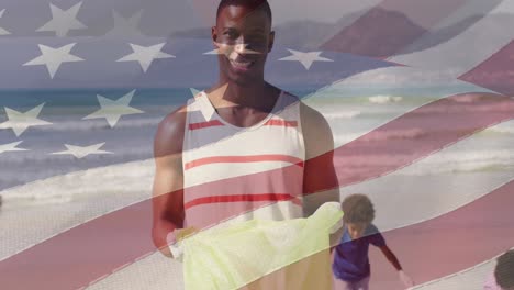 animación de la bandera de los estados unidos de américa sobre un feliz padre e hijo afroamericanos en la playa