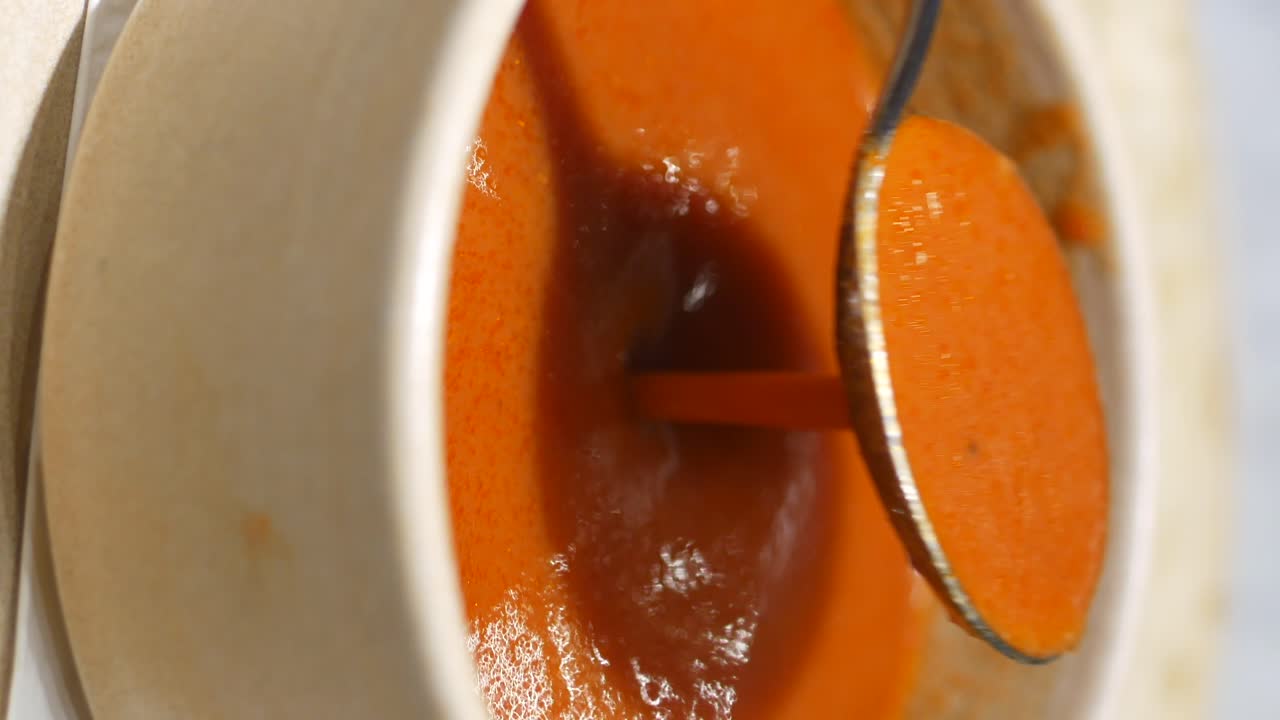 Close-up of a bowl of hot, orange soup