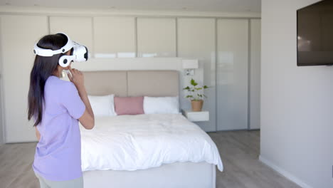 using vr headset, woman exploring virtual reality in modern bedroom, copy space